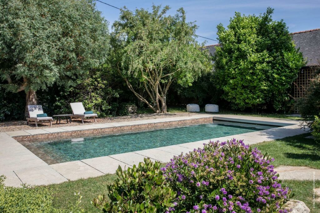 Piscine avec massifs de fleurs dans un cadre naturel par Créa'Paysage